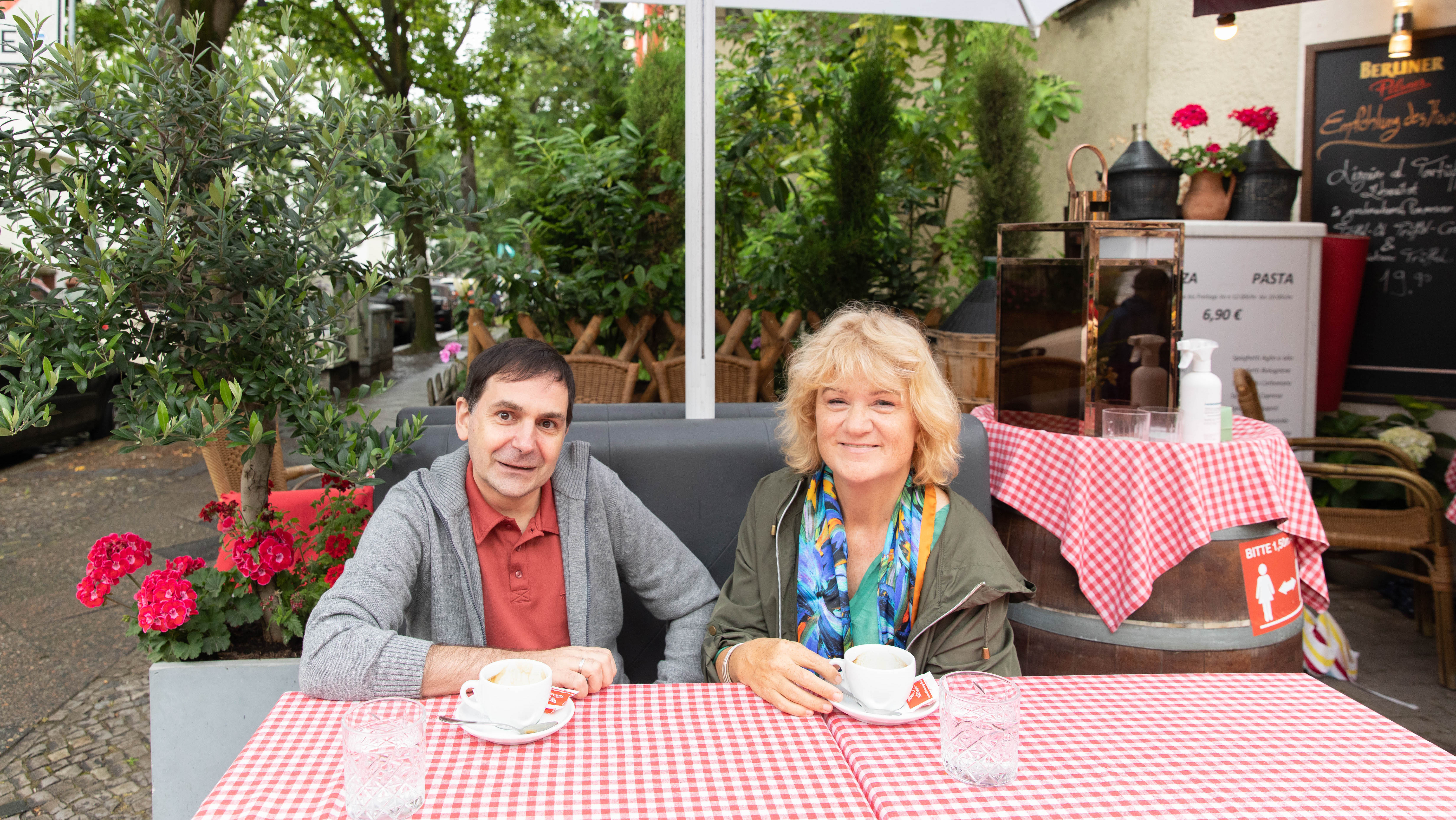 Enrico B. und Iris Nußbaum sitzen an einem Tisch.
